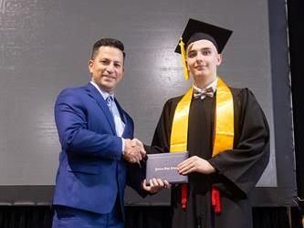 Principal posing with graduating senior