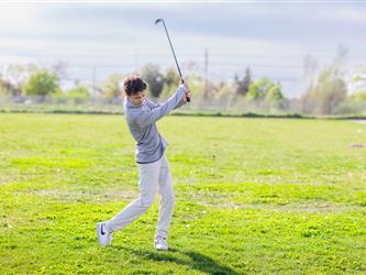 Golf player swinging ball