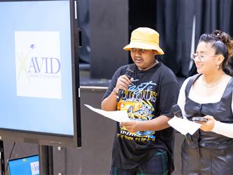 Students reading from paper into microphone