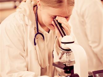 A student is looking through a microscope