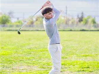 Golf player swinging ball