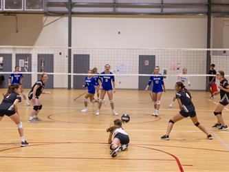 Girls playing indoor volleyball