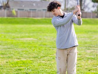 Golf player swinging ball