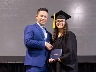 Principal posing with graduating senior