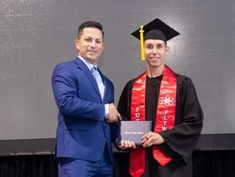Principal posing with graduating senior