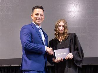 Principal posing with graduating senior