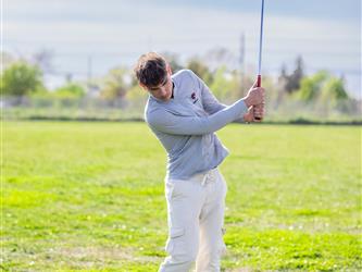 Golf player swinging ball