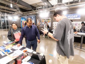 A student is demonstrating their project to two parents