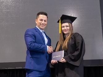 Principal posing with graduating senior