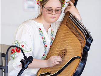 Student playing harp like instrument