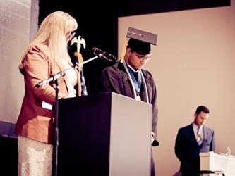 Superintendent speaking at podium recognizing student