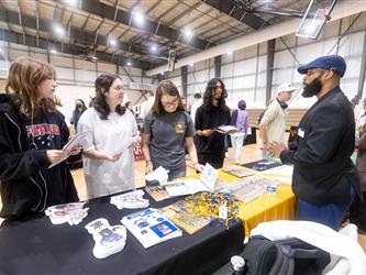 Students reviewing materials and speaking with recruiters