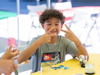 student posing at craft table 