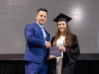 Principal posing with graduating senior