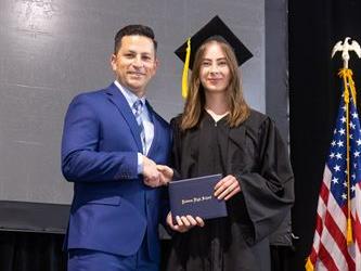 Principal posing with graduating senior