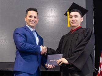 Principal posing with graduating senior