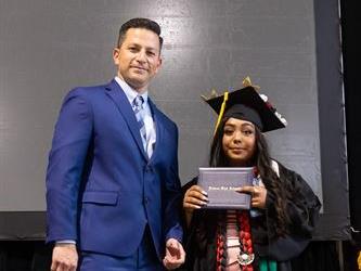 Principal posing with graduating senior