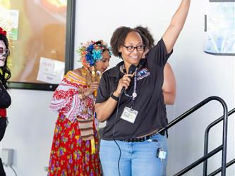 staff member posing on stage with child