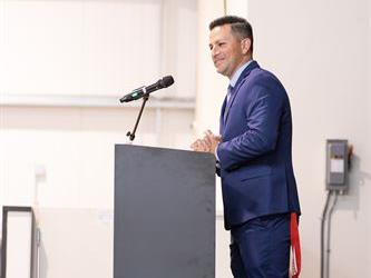 Principal speaking at podium on stage