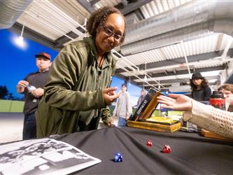 A staff member rolls dice for the students dungeons and dragons table