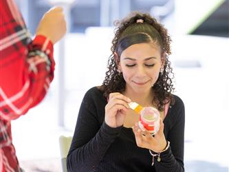 student painting a jar 