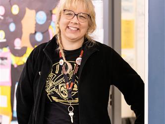 A teacher is pictured at her door 