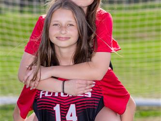 Girls soccer team players piggyback riding