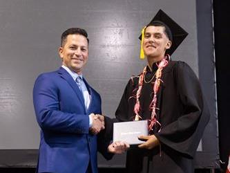 Principal posing with graduating senior