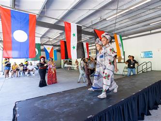 2 students on stage in cultural attire 