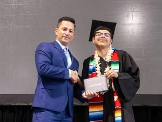 Principal posing with graduating senior