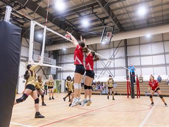 Futures Girls Volleyball team defending the net