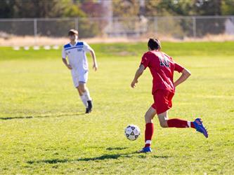 Student running after player with ball