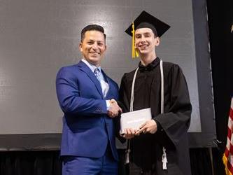 Principal posing with graduating senior