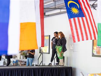 A student is painting a personal fan 