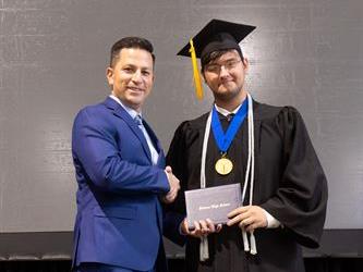 Principal posing with graduating senior