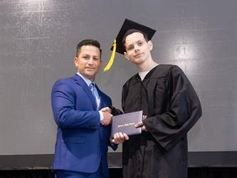 Principal posing with graduating senior