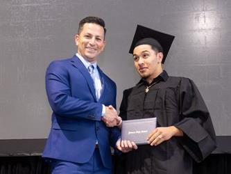 Principal posing with graduating senior