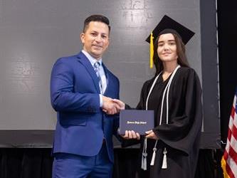 Principal posing with graduating senior