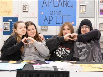 4 students are making hearts with their hands
