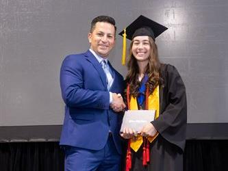 Principal posing with graduating senior