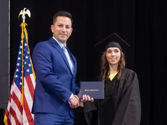 Principal posing with graduating senior