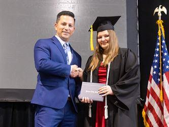 Principal posing with graduating senior