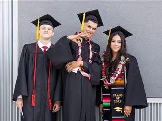 Three students smiling on camera