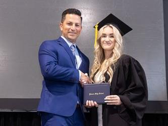 Principal posing with graduating senior