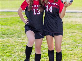 Girls soccer team players posing together