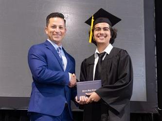 Principal posing with graduating senior