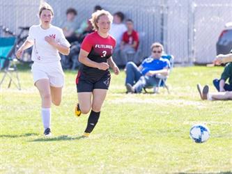 Soccer players going after ball